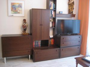 a entertainment center with a tv and a dresser at Privat Apartment in Bad Hofgastein