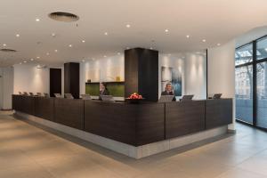 a lobby with two people sitting at a reception desk at Estrel Berlin in Berlin