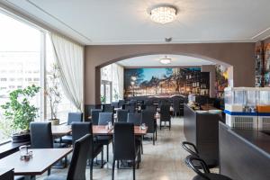 a dining room with tables and chairs and a painting on the wall at Belfort Hotel in Amsterdam