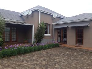 a house with purple flowers in front of it at Balfour Lodge in Balfour