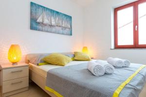 ノヴァリャにあるMaru Apartmentsのベッドルーム1室(ツインベッド2台、タオル付)