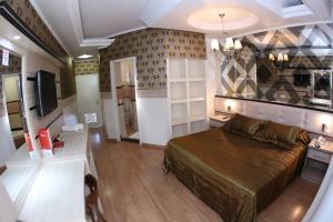 a bedroom with a bed and a desk and a television at Hotel Premier in Santa Rita