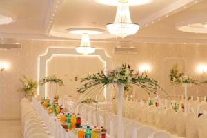 uma mesa longa com cadeiras brancas e flores num quarto em Pod Szczęśliwą Gwiazdą em Cekanowo