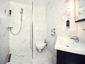 a bathroom with a shower and a toilet and a sink at Belfort Hotel in Amsterdam