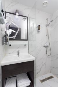 een witte badkamer met een wastafel en een douche bij Belfort Hotel in Amsterdam