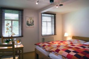 a bedroom with a bed and a desk and windows at Gästezimmer der Adler Wirtschaft in Hattenheim