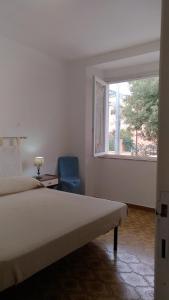 カーラゴノネにあるAppartamento Cala Gononeのベッドルーム1室(ベッド1台、窓、椅子付)