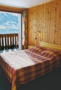 a bedroom with a bed and a large window at Edelweiss in Samoëns