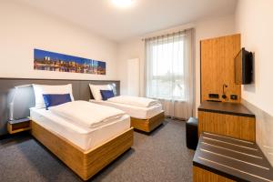 ein Hotelzimmer mit 2 Betten und einem TV in der Unterkunft Motel Grieskirchen superior in Grieskirchen