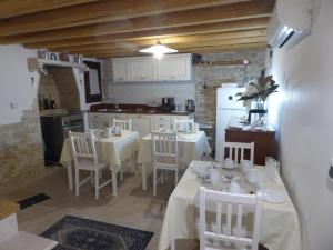 a kitchen with white tables and chairs in a room at Casa Perla in Chioggia