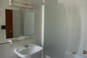 a white bathroom with a sink and a mirror at Hotel Vazquez Diaz in Nerva