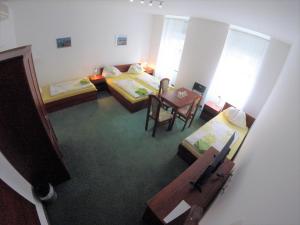 a room with two beds and a table and chairs at Pension San Francisco in Vienna