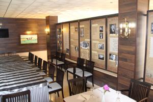 a dining room with tables and chairs and pictures on the wall at Hotel Vazquez Diaz in Nerva