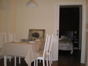 a dining room with a table and chairs with a table and a bed at Apartamentos Murallas de Sevilla in Seville