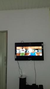 TV de pantalla plana colgada en la pared en Expedito acomodações, en Manaus