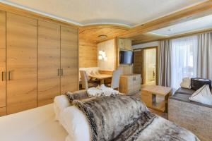 1 dormitorio con cama, mesa y sofá en Oberlechtaler Hof Boutique Hotel en Holzgau