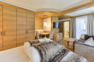 ein Schlafzimmer mit einem Bett, einem Tisch und einem Sofa in der Unterkunft Oberlechtaler Hof Boutique Hotel in Holzgau