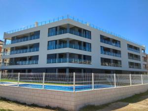 an apartment building with a swimming pool in front of it at Luxury and Modern Beach Apartment with Sea Views in La Mata