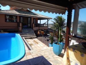 ein Haus mit Pool neben einem Haus in der Unterkunft Guesthouse Saint Tropez in Arraial do Cabo