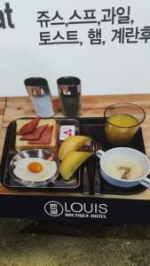 ein Frühstückstablett mit Eiern und Obst auf dem Tisch in der Unterkunft Louis Boutique Hotel in Changwon