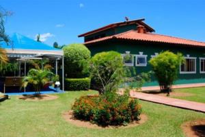 a green house with a garden in front of it at Hotel Fazenda 7 Belo in Socorro
