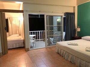 a hotel room with two beds and a balcony at Naithon Beach Residence in Nai Thon Beach