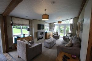 a living room with two couches and a tv at Tweed Lodge in Perth