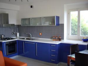una cocina con armarios azules y fregadero en Sea view apartment 10 minute walk to the sea, en San Vito Chietino