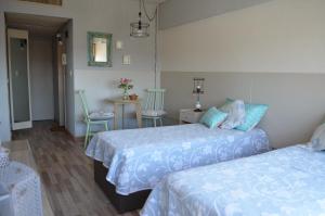 una camera da letto con due letti, un tavolo e delle sedie di Torre Obelisco a Buenos Aires Altre 27 foto