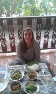 a woman sitting at a table with plates of food at Garden Home, Chanthaburi in Ban Bo