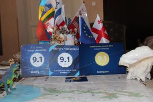 a table topped with three blue boxes and a dinosaur at Giorgi's Homestay in Kutaisi