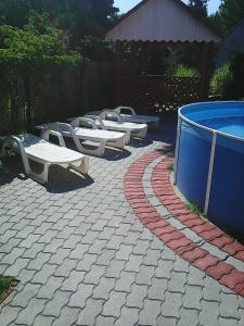 a group of picnic tables and a swimming pool at Árvácska Nyaraló in Balatonmáriafürdő