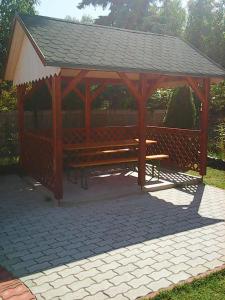 un pabellón de madera con una mesa de picnic en un parque en Árvácska Nyaraló en Balatonmáriafürdő