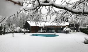 a house with a swimming pool covered in snow at Le Lagon in Jargeau