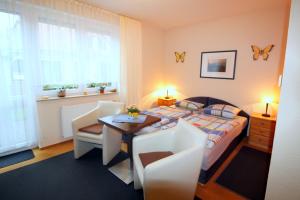 ツィングストにあるFeriendomizil am Hafenのベッドルーム1室(ベッド1台、テーブル、椅子付)