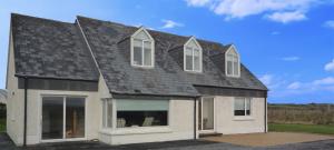 Casa grande con techo negro y ventanas en El Martins, en Miltown Malbay