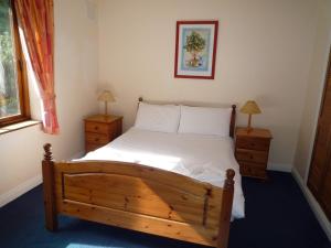 ダンモア・イーストにあるPine Cove Holiday Homesのベッドルーム1室(木製ベッド1台、ナイトスタンド2台付)