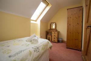 a bedroom with a bed and a window and a mirror at Willow Grove Holiday Homes No 4 by Trident Holiday Homes in Rosslare
