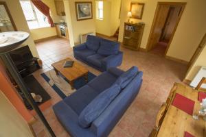 a living room with a blue couch and a table at Willow Grove Holiday Homes No. 4 in Rosslare