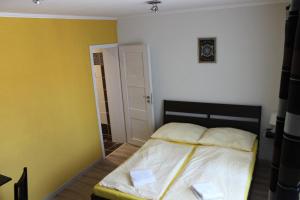 - une chambre avec un lit aux murs jaunes et blancs dans l'établissement Pokoj pro dva s výhledem, à Český Krumlov