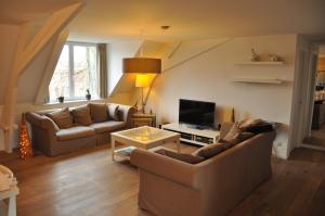 a living room with two couches and a tv at Albertushof in Ieper