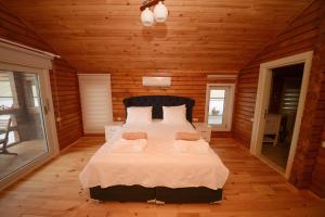カルカンにあるEco Villa Menekşeの木製の部屋に大型ベッドが備わるベッドルーム1室が備わります。