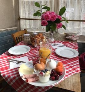 uma mesa com um prato de comida numa toalha de mesa vermelha e branca em Les Epis d'Or em LʼIsle-sur-Serein
