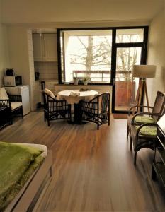 a living room with a table and chairs and a window at Ruhiges Apt. direkt am Naherholungsgebiet mit Seeblick, Zentrum 5min, Messe 18min in Nürnberg