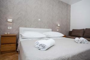 1 dormitorio con 1 cama con toallas en Villa Makarana Apartments, en Makarska