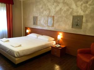 um quarto de hotel com uma cama e uma cadeira em Hotel Forum em Rozzano