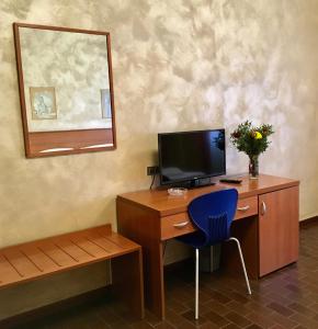 Pokój z biurkiem z komputerem i niebieskim krzesłem w obiekcie Hotel Forum w mieście Rozzano
