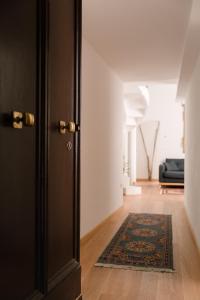 ボローニャにあるGrande, moderno appartamento in edificio storicoのウッドフロアの客室で、ドアと敷物が備わります。