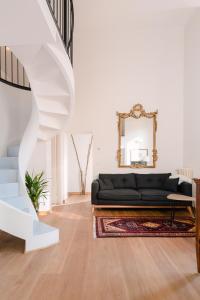 a living room with a black couch and a mirror at Grande, moderno appartamento in edificio storico in Bologna