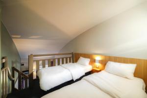 Un pat sau paturi într-o cameră la B&B HOTEL Nantes Atlantis Le Zenith